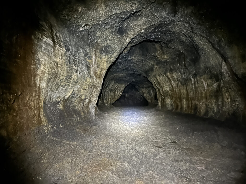 Inside the Ape Cave lava tube, with a smooth floor and arching walls.