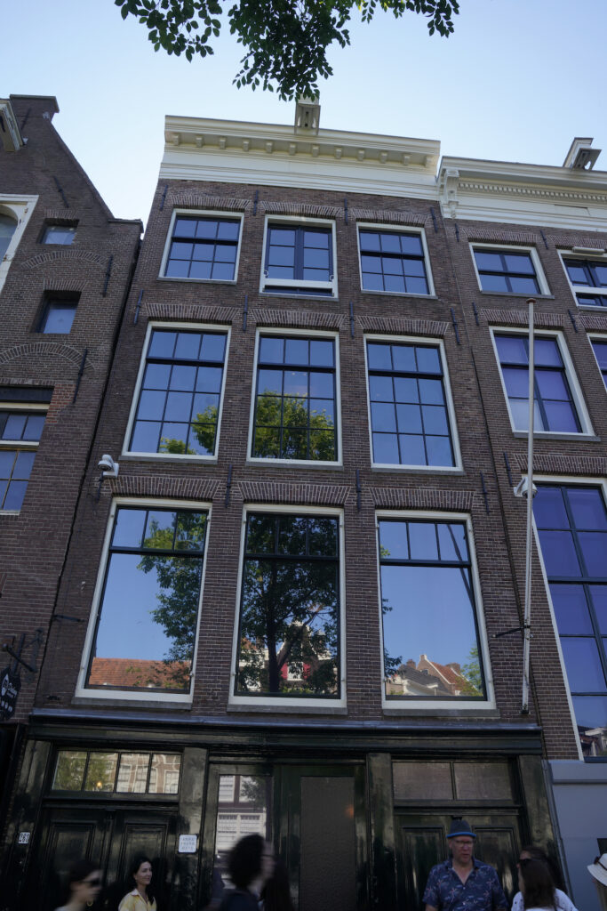 Tourists pass by Anne Frank House in Amsterdam.