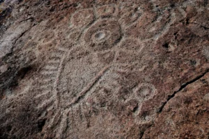 A petroglyph in a boulder at Cove Palisades State Park displays circles, lines, and squiggles.