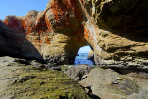 Looking out to sea through the arch in the rock wall at Devil's Punchbowl on the Oregon Coast.