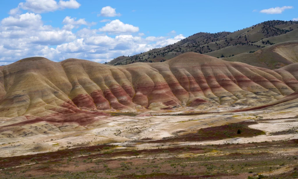 Red stripes cross the face of Painted Hills on a pleasant spring day.