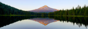 Mount Hood is reflected on the surface of Trillium Lake during a clear sunset.