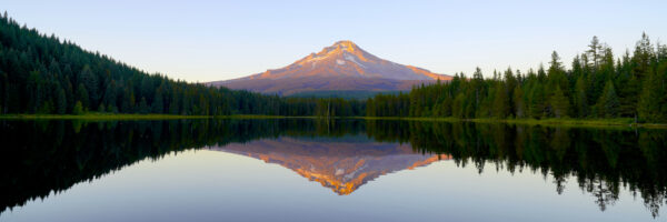 Mount Hood is reflected on the surface of Trillium Lake during a clear sunset.