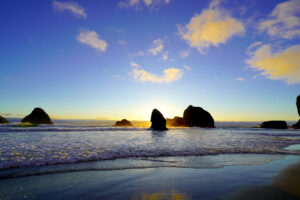 Golden clouds and blue skies mix into a pretty sunset at Tunnel Beach.