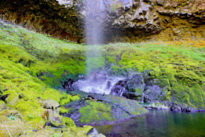 Green moss covers every rock around the base of wispy Wy'East Falls.