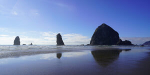 Cannon Beach features a group of three major offshore - aptly-named Haystack Rock is on the right, with The Needles, a pair of tall and skinny sea stacks, at center and left.