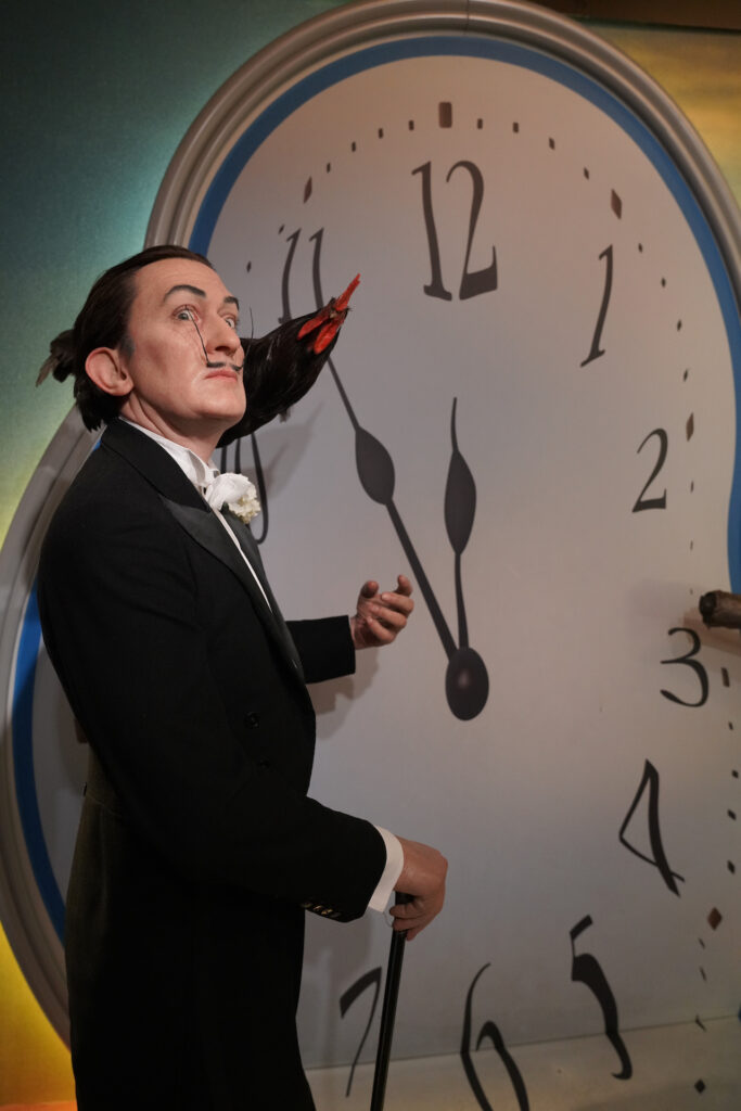 A wax figure of Salvador Dali standing beside an enlarged version of one of his melting clocks in Madame Tussauds Amsterdam.