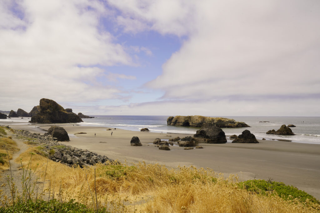 Parting clouds begin to reveal blue sky above Meyers Creek Beach on the Oregon Coast on a summer morning.