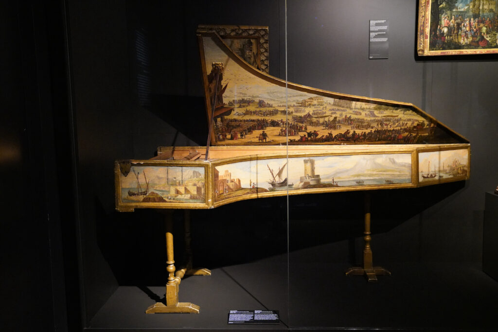 A harpsichord, beautifully painted with rural nature scenes, stands silently in Rijksmuseum's Special Collections area.