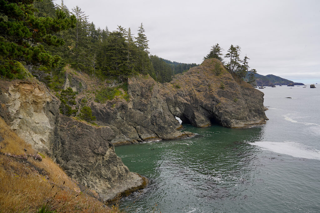 Looking down the picturesque Oregon Coast toward the Natural Bridges formation on a cloudy summer day.