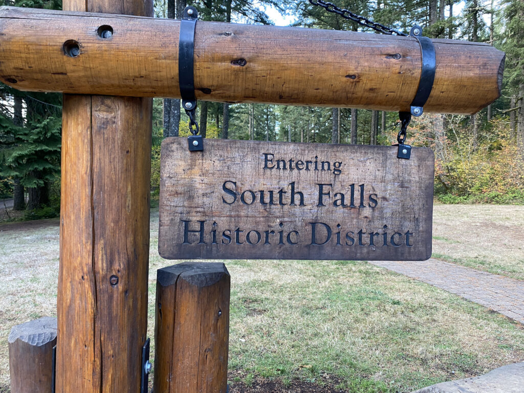 A picture of a wooden sign which says "Entering South Falls Historic District" in Silver Falls State Park, Oregon.