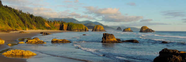 A sweeping view of the northern Oregon Coast lit by warm afternoon sunshine.