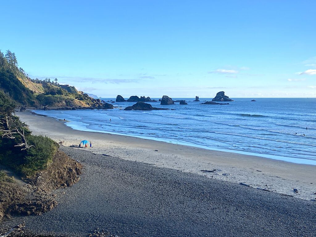 The last group start packing up their shade canopy as evening descends on Indian Beach in Ecola State Park, Oregon.