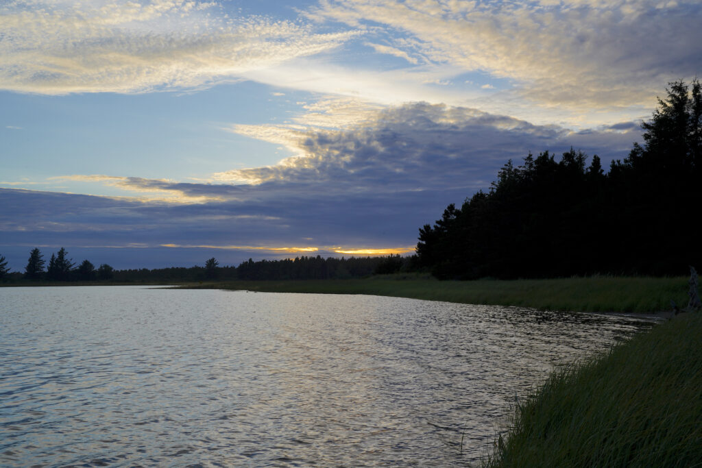 A stripe of sunset color slashes through the dark clouds at Trestle Bay in Fort Stevens State Park near Astoria, Oregon.