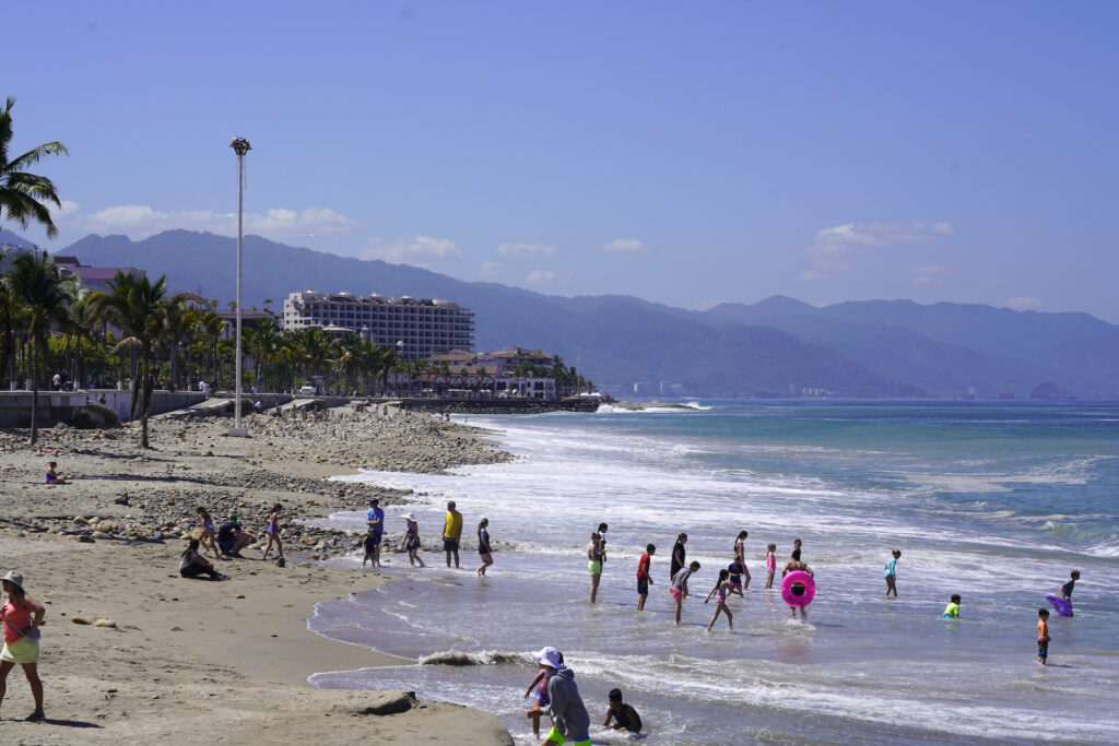 Beachgoers come in and out of the water at Playa Malecon in Puerto Vallarta.
