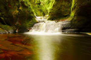 Red sandstone makes the creek appear like blood in The Devil's Pulpit, Scotland.