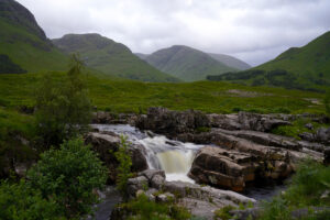 A small waterfall pours through Glen Etive, Scotland.