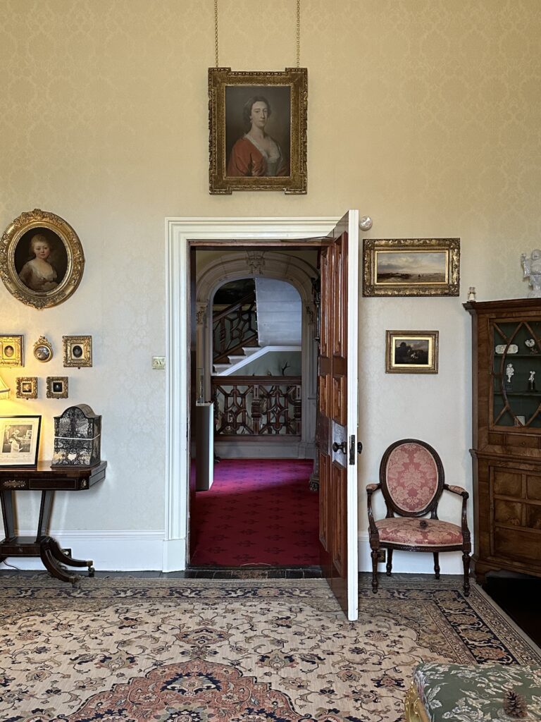 Looking out from inside a parlor into the hallway of Brodick Castle in Scotland.