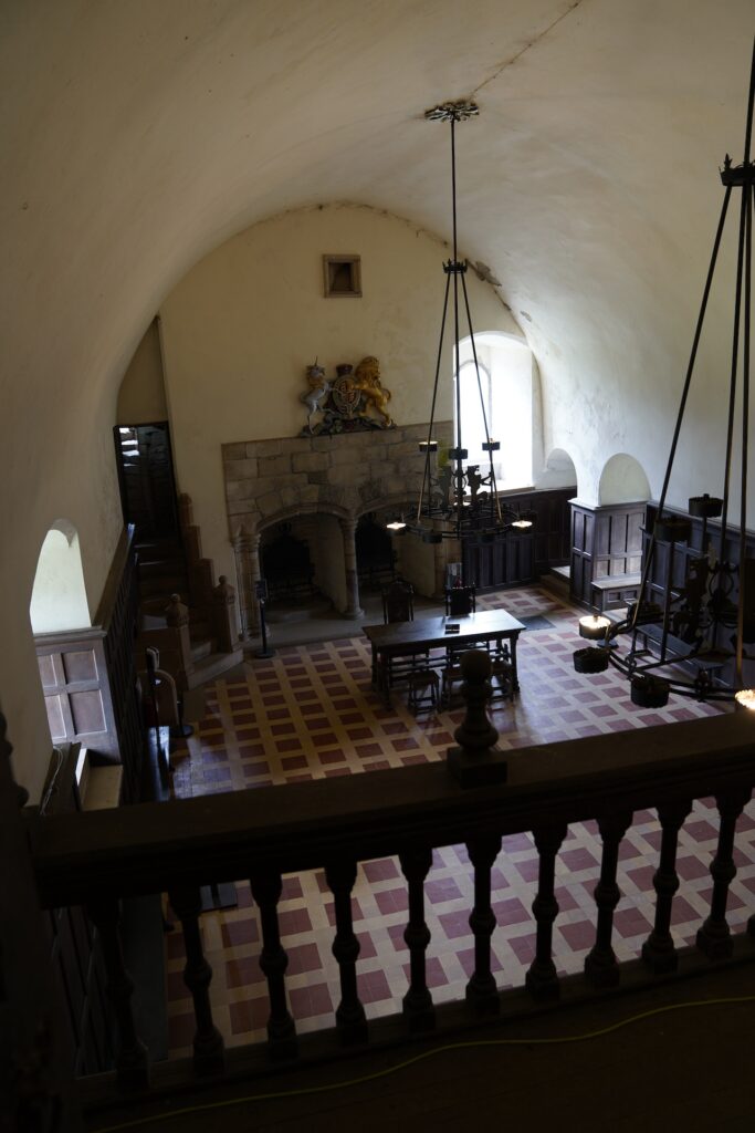 Looking over a lbalcony railing to the great hall of Duone Castle below.