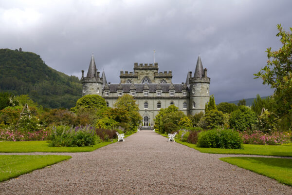 A fairytale-style Baroque castle rises behind a formal garden in Scotland.