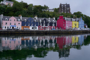 The colorful buildings on the waterfront at Tobermory are reflected in the bay's calm waters.