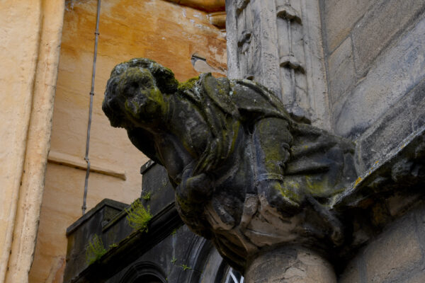 A time-worn grotesque of a female figure peers out from the side of Stirling Castle in Scotland.