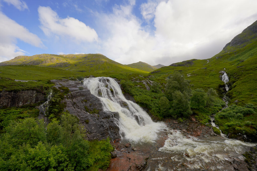 The Meeting of Three Waters in Glen Coe, Scotland includes one large waterfall and a second smaller falls.