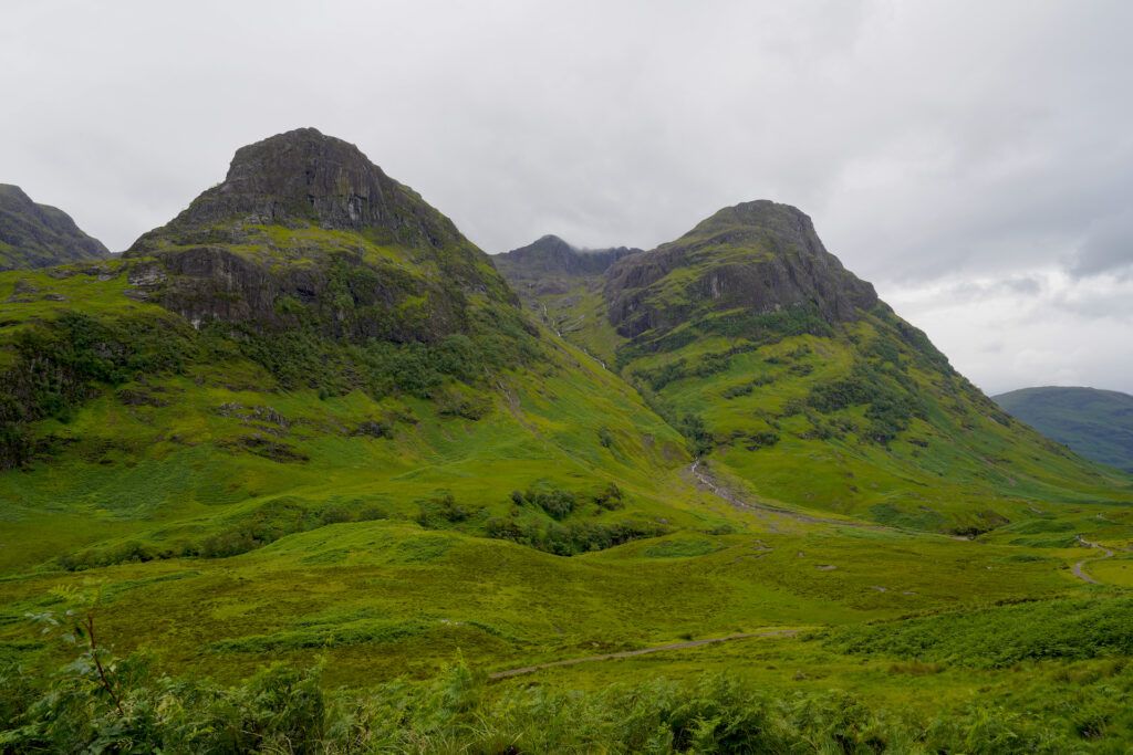 The Three Sisters mountains rise above the green valley of Glen Coe, Scotland.