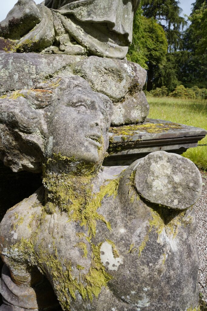 A toppled statue of a person in the garden of Inveraray Castle, Scotland.