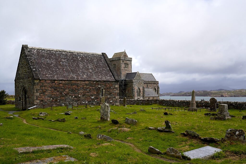 St Oran's Chapel stands in front of Iona Abbey with a kirkyard surrounding it on Scotland's Isle of Iona.