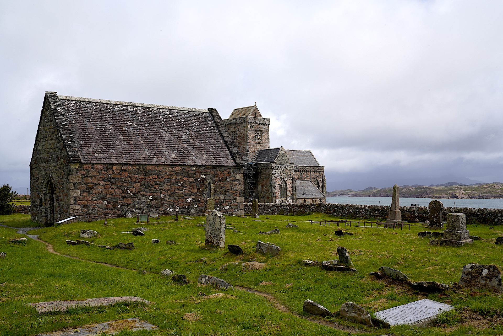 St Oran's Chapel stands in front of Iona Abbey with a kirkyard surrounding it on Scotland's Isle of Iona.