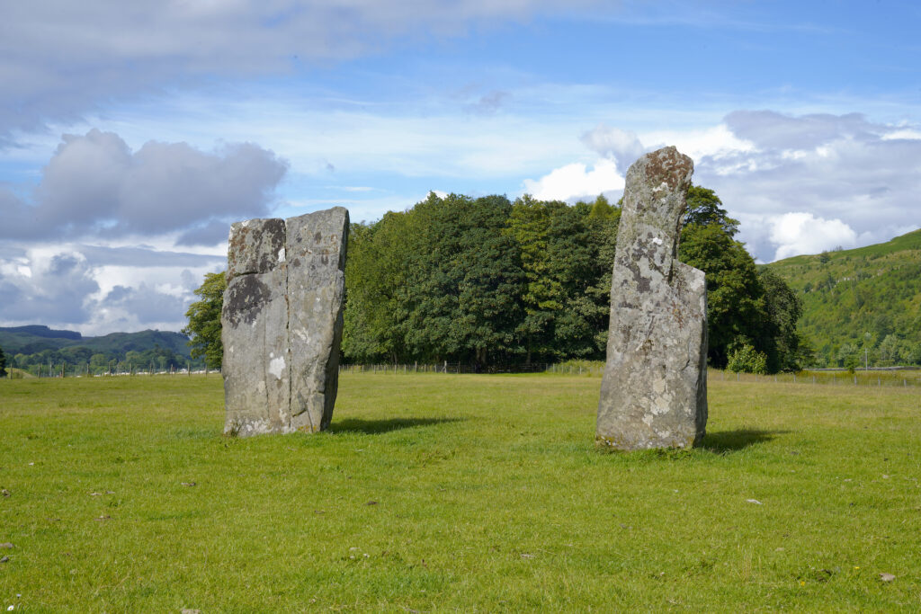 A pair of standing stones placed thousands of years ago rise from a field in Kilmartin Glen, Scotland.